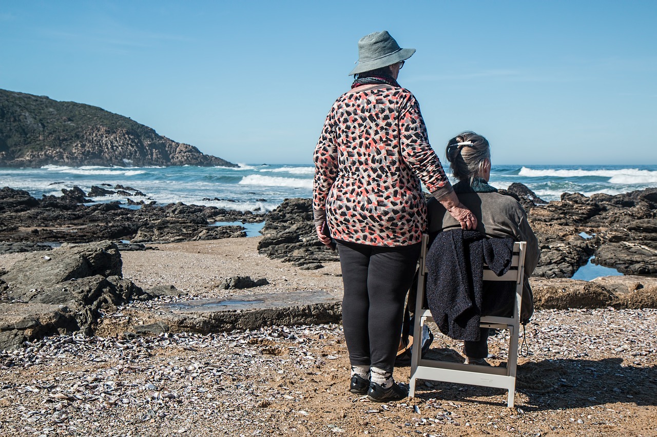 senior women, sitting on a beach